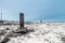 A broken telegraph pole on a snow-covered Arctic hill. Minimalistic polar landscape