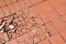 The broken tile floor. Damaged tile flooring caused by impact with heavy objects.