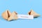 Broken up and whole fortune cookie with motivational text `This too shall pass` on paper note on blue background