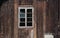 Broken window at an abandoned weathered shed