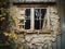 A broken window in the wall of a dilapidated and abandoned house.