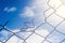 Broken Wire Fence and Blue Sky Background