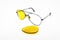 Broken yellow sunglasses lens on white background