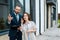 Broker holding clipboard and gesturing near attractive woman