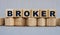 BROKER - word on wooden cubes on a beautiful gray background