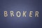 Broker written with wooden letters on a blue background