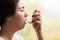 Bronchial asthma. Close-up portrait of a young woman holding an inhaler to her mouth. Side view