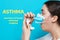 Bronchial asthma. Close-up portrait of a young woman in a medical mask holding an inhaler to her mouth. Side view. Text