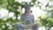 Bronze Buddha Statue in Traditional Sitting Meditation Pose on Shimmering Blurred Background