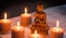 Bronze Buddha with warm lighted candles over limestone background