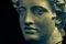 Bronze color gypsum copy of ancient statue Apollo God of Sun and Poetry head for artists on dark background. Renaissance