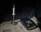 Bronze cross, burning candle and bible on the table