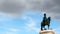 Bronze equestrian statue against blue sky