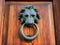 Bronze lionâ€™s head with a ring door knocker on an old wooden door