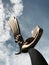 Bronze sculpture of a bird against blue sky