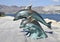 The bronze sculpture of three dolphins on the beach