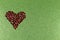 Bronze sequin heart on shimmering green background