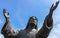 Bronze statue of Jesus looking at the sky with both arms up