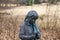 A bronze statue of a little girl with pony tails surrounded by yellow winter grass and fallen autumn leaves