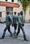 Bronze statues depicting three young men in a small square in Pistoia.