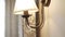 Bronze wall sconce lamp with fabric lampshade and pendants turns on and off.