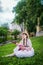 Brooding girl in a white dress sitting on grass