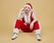 Brooding young guy in a Santa suit on a yellow background