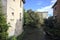 Brook bordered by houses and plants on a sunny day in the italian countryside