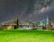 The Brooklyn Bridge with milky way with Manhattan skyline on background and green meadow in foreground, New York City