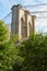 Brooklyn Bridge pillar with green trees in New York