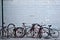 Brooklyn, New York: A group of bicycles chained to sign posts and curbside bike stands on an urban sidewalk