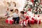 Brother in deer Christmas hat kissing his younger sister in head