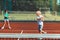 Brother hitting the tennis ball while playing with sister
