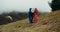 Brother hug his little sister stand on mountain hill on travel in cloudy day