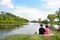 Brother and little sister sitting on the bank of the river.