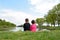 Brother and little sister sitting on the bank of the river.