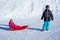 Brother pulling his sister kids toboggan sled snow. Little girl and boy enjoying sleigh ride. Child sledding. Children