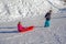 Brother pulling his sister kids toboggan sled snow. Little girl and boy enjoying sleigh ride. Child sledding. Children