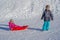 Brother pulling his sister kids toboggan sled snow. Little girl and boy enjoying sleigh ride. Child sledding. Children