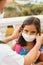 Brother puts on her sister sterile medical mask. Child, wearing face mask, protect from infection of virus, pandemic, outbreak and