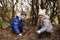 Brother and sister building a campfire, looking to camera