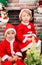 Brother and sister dressed costume Santa Claus by fireplace.