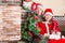 Brother and sister dressed costume Santa Claus by fireplace. Christmas
