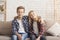 Brother And Sister Embracing Smiling Sitting On Couch At Home