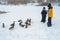 Brother and sister feed hungry ducks with bread