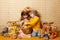 Brother and sister with hare ears and toys hares are sitting with a basket full of Easter eggs. family holiday at home