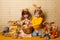 Brother and sister with hare ears and toys hares are sitting with a basket full of Easter eggs. family holiday at home