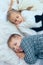 Brother and sister lying in the bed.The younger brother prevents the older sister from sleeping.