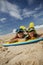 Brother and sister lying on the sand