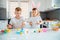 Brother and sister painting Easter eggs. Children make holiday decorations while sitting at the kitchen table.